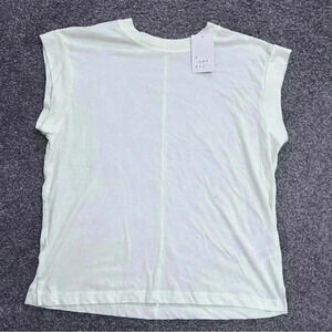 NWT. Pastel yellow, extended shoulder T shirt. Size XS